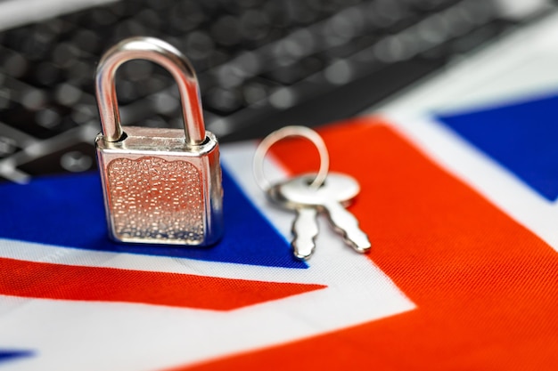 Концепция кибербезопасности Соединенного Королевства Замок на клавиатуре компьютера и флаг Великобритании Крупным планом фото