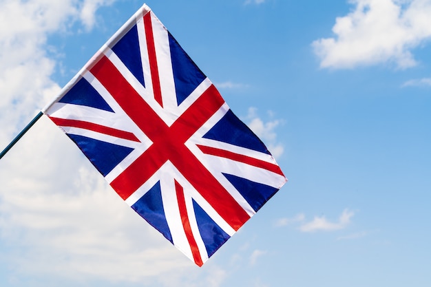 Photo united kingdom flag waving on wind in blue sky