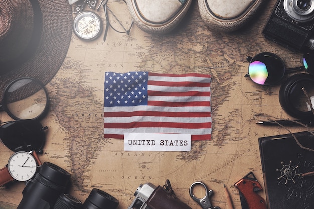 United States of America Flag Between Traveler's Accessories on Old Vintage Map. Overhead Shot