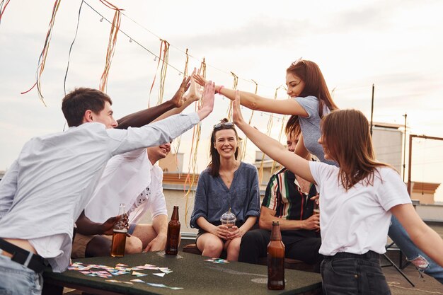 Unity of people Group of young people in casual clothes have a party at rooftop together at daytime