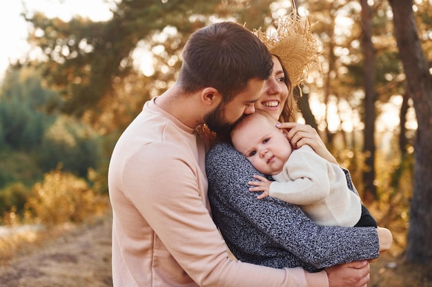 Unity of the people happy family of mother family and little\
baby rests outdoors beautiful sunny autumn nature