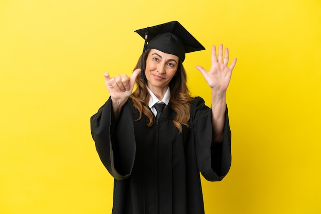 Universitair afgestudeerde van middelbare leeftijd geïsoleerd op een gele achtergrond die zes met vingers telt