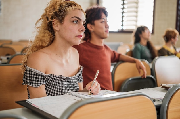 Universitaire studenten van verschillende afkomst die de uitleg van de leraar in de klas bijwonen