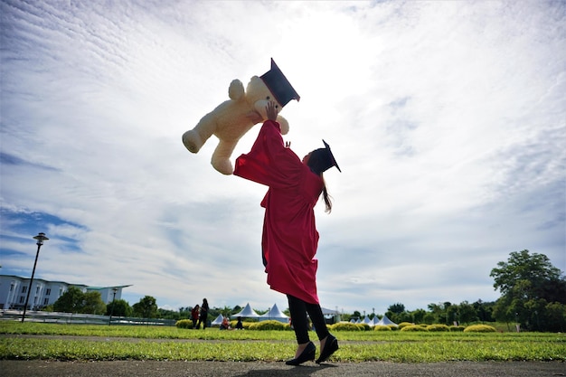 Universiteitsstudent gooit een teddybeer tegen de lucht tijdens het afstuderen
