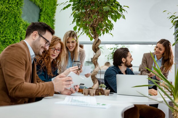 University colleague biologists taking experiment on sprout and checking the analysis of the sample of plant on the digital tablet