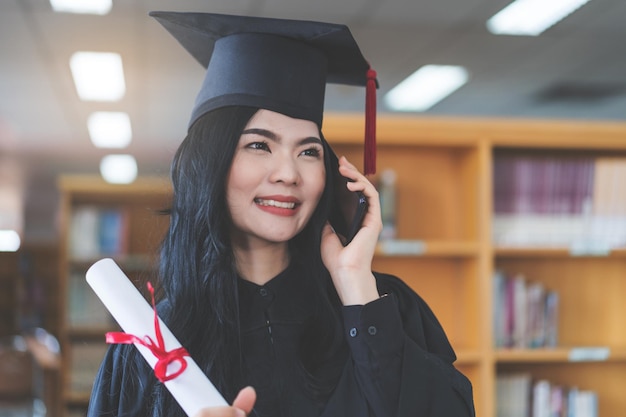 졸업 가운과 모르타르보드를 입은 대학 졸업생이 가상 졸업식에서 축하합니다.