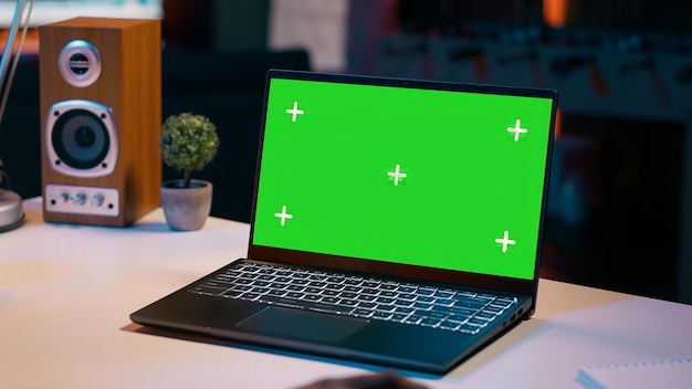 University student checks greenscreen display on laptop at home