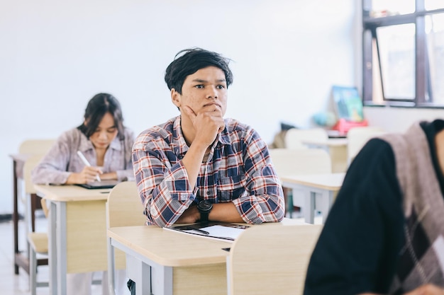 University student listening lecture while attending a class in the classroom