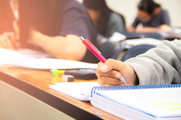 Foto gli studenti universitari fanno quiz, test o studi dell'insegnante in una grande aula. studenti in uniforme che frequentano la scuola educativa per esame.