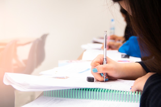 Gli studenti universitari fanno quiz, test o studi dell'insegnante in una grande aula. studenti in uniforme che frequentano la scuola educativa per esame.