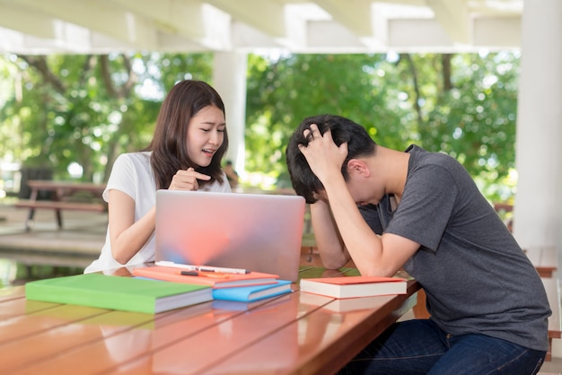 Foto studenti universitari con notebook; preoccupato per i compiti, il rapporto deve essere inviato all'istruttore