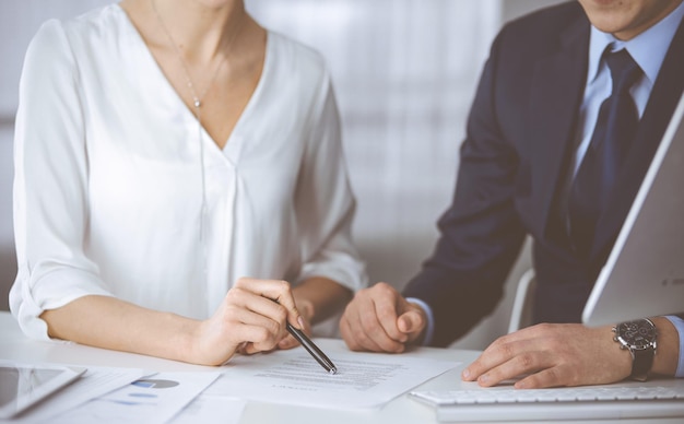 Unknown businessman and woman discussing contract in office. closeup.Business people or lawyers working together at meeting. Teamwork and partnership.