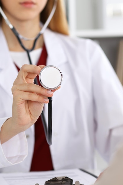 Unknown female doctor with a stethoscope in the hands. Physician is redy to exemine a patient. Medicine and health care conept