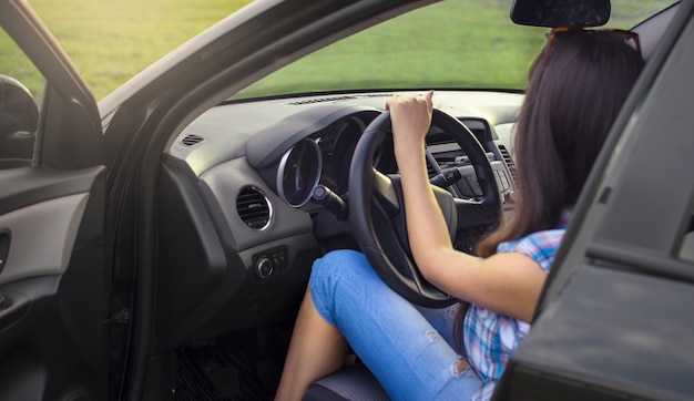 Unknown girl driving a black car.