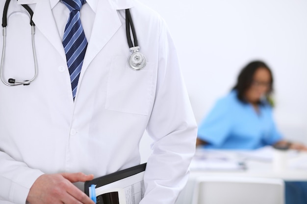 Unknown male doctor with stethoscope and clipboard close up