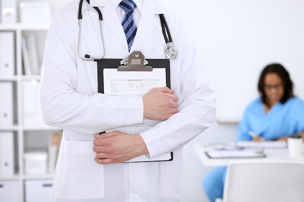 Unknown male doctor with stethoscope and clipboard close up