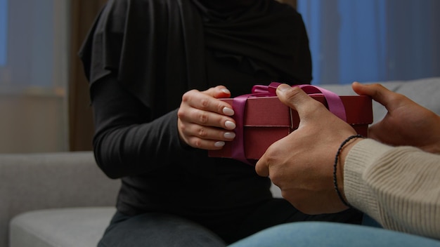 Unknown man congratulate beloved woman give surprise pink box with ribbon indoors female hands