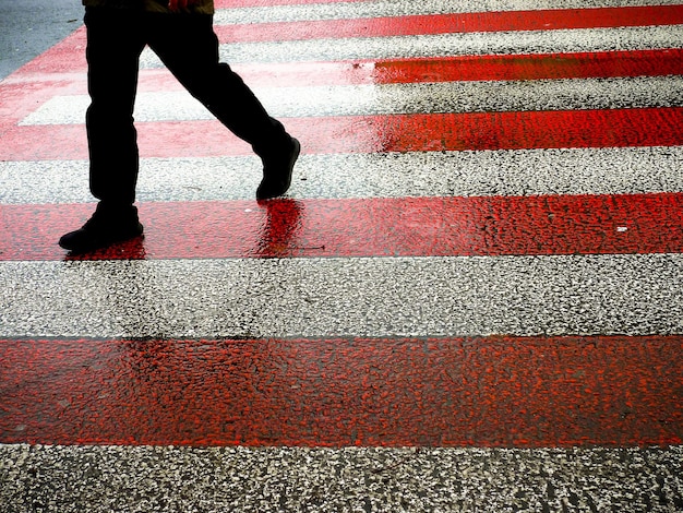 Unknown man on wet zebra crossing