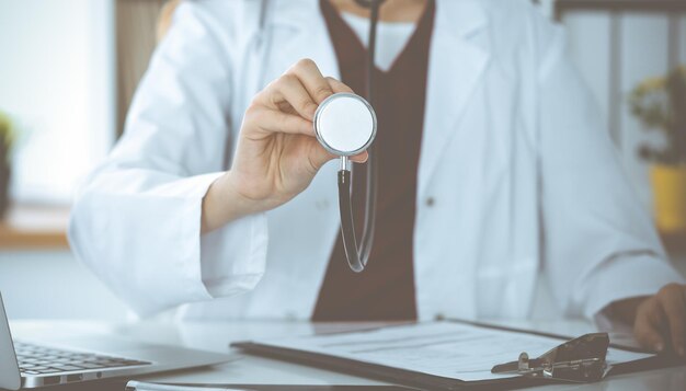 Unknown woman-doctor with a stethoscope in the hands. Physician is ready to examine a patient, close-up of hands. Medicine concept.