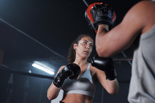 Unleash your inner beast Shot of a young woman practicing with her coach at a boxing gym