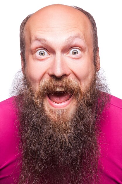 Unleashed emotions. Frustrated young man with blue opened eyes and mouth opened while standing looking at camera, isolated on white background.