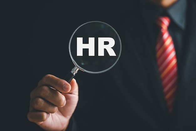 Photo unlocking hrm potential magnifier glass highlights manager icon in staff icons representing power of human resource management in recruitment leadership employee development employees selection