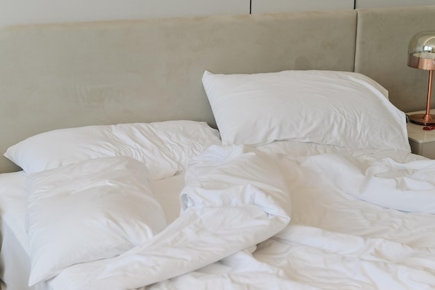 Unmade bedding sheets and pillow Unmade messy bed after comfortable sleep concept