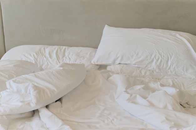 Unmade bedding sheets and pillow Unmade messy bed after comfortable sleep concept