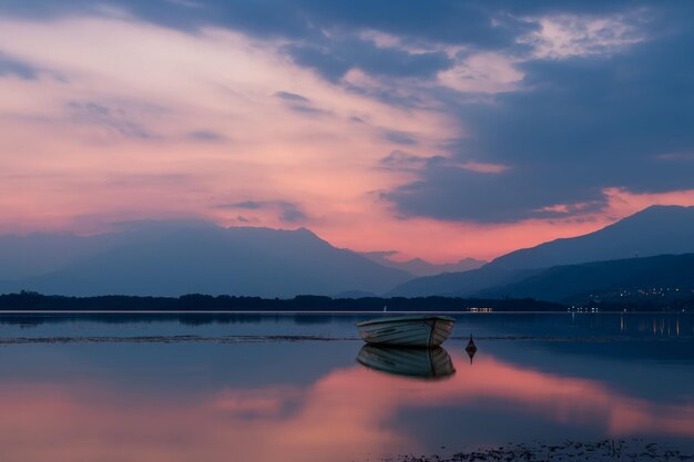 Unmanned boat floating on a calm coast under a beautiful sunset