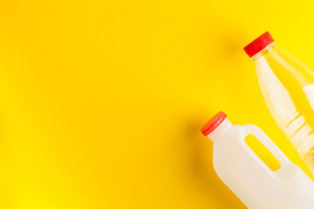 Unmarked biodegradable plastic milk bottles on a yellow background concept of dairy products zero wa...