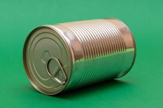 Unopened tin can with blank edge on green background canned\
food aluminum can for safe and long term storage of food steel\
sealed food storage container