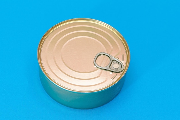 Unopened tin can with blank edge on light blue background