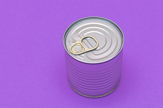 Photo unopened tin can with blank edge on violet background