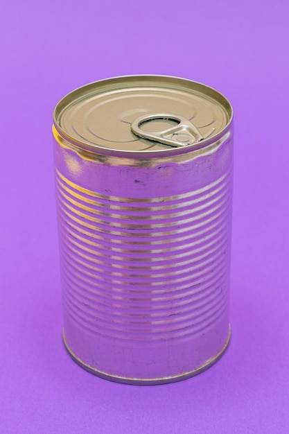 Unopened tin can with blank edge on violet background