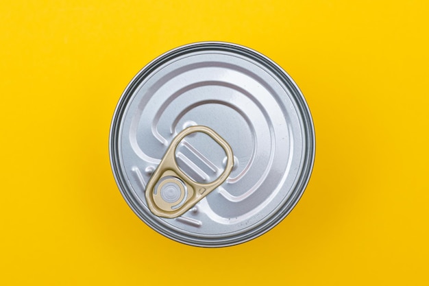 Unopened tin can with blank edge on yellow background canned food aluminum can for safe and long term storage of food steel sealed food storage container