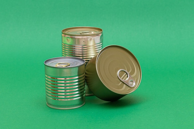 Unopened tin cans with blank edges on green background