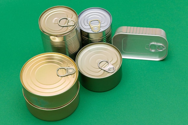 Unopened tin cans with blank edges on green background