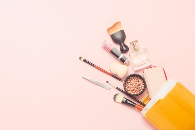 Unpacked delivery package with goods on a pink background. Concept parcel, cargo, order from China, a variety of products, online store, skin care cosmetics and makeup. Flat lay, top view.