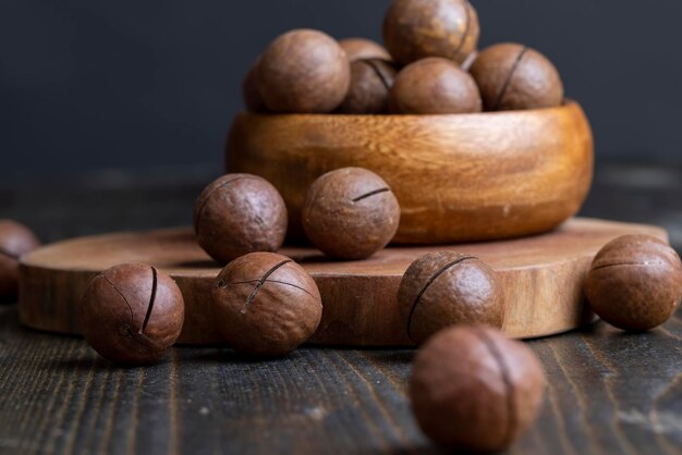 Unpeeled macadamia nuts on a wooden table