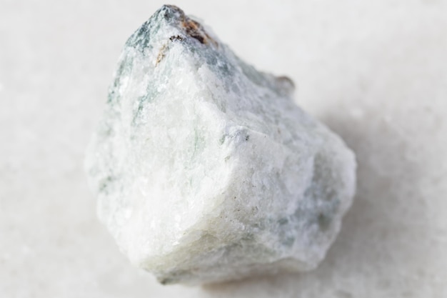 Unpolished Carbonatite rock on white marble