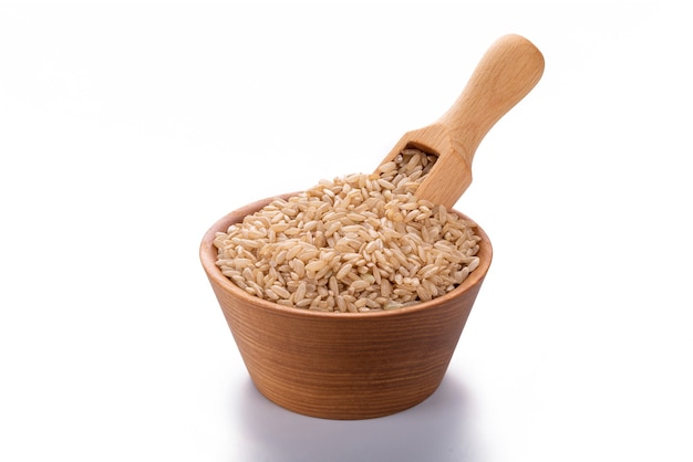 Unpolished wild brown rice rice in a wooden scoop and in a bowl isolated on white background