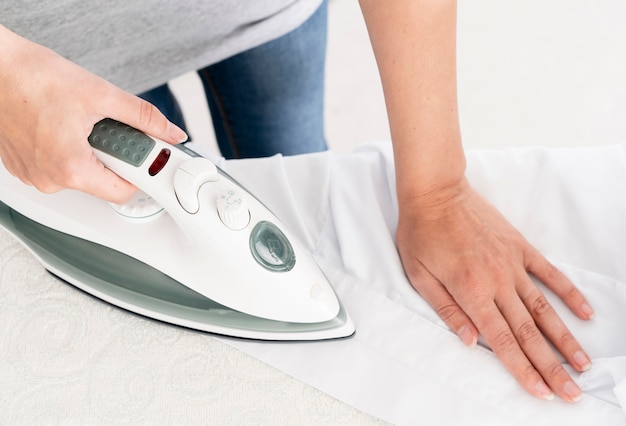 Photo unrecognisable female ironing clothes