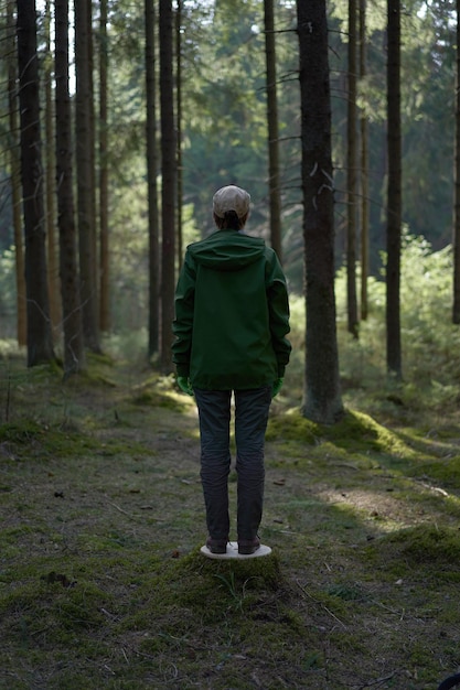 Unrecognisable man in a green plastic mask in the forest as a symbol Ecology theme