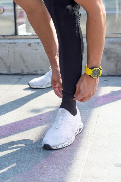 Unrecognizable athlete man adjusting his socks