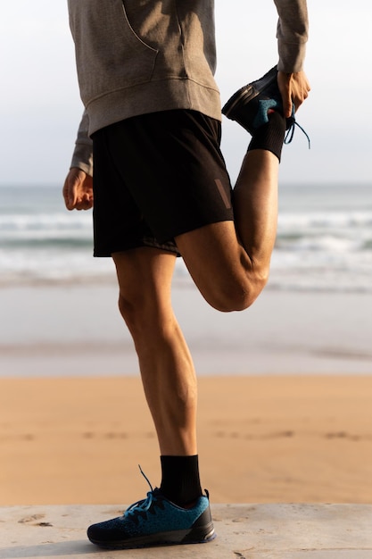 Unrecognizable athlete stretching outdoors at the beach