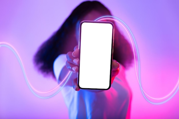 Unrecognizable black woman hiding behind phone with blank screen mockup