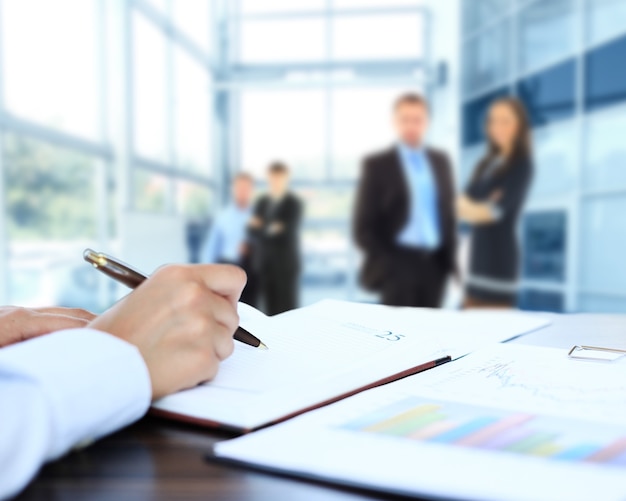 Unrecognizable business person analyzing graphs and taking notes