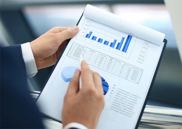 Photo unrecognizable business person analyzing graphs and taking notes