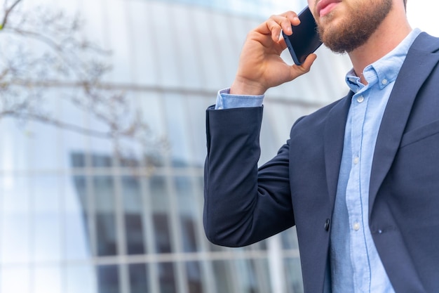 Foto uomo d'affari o persona finanziaria irriconoscibile durante una chiamata di lavoro fuori dall'ufficio