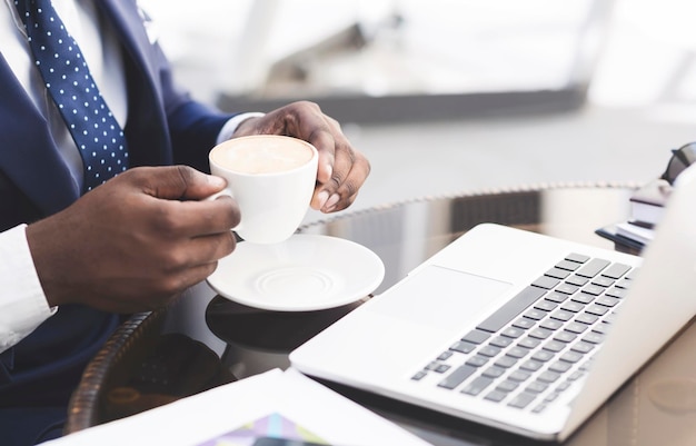 Unrecognizable Businessman Having Coffee Working On Laptop In Cafe Closeup
